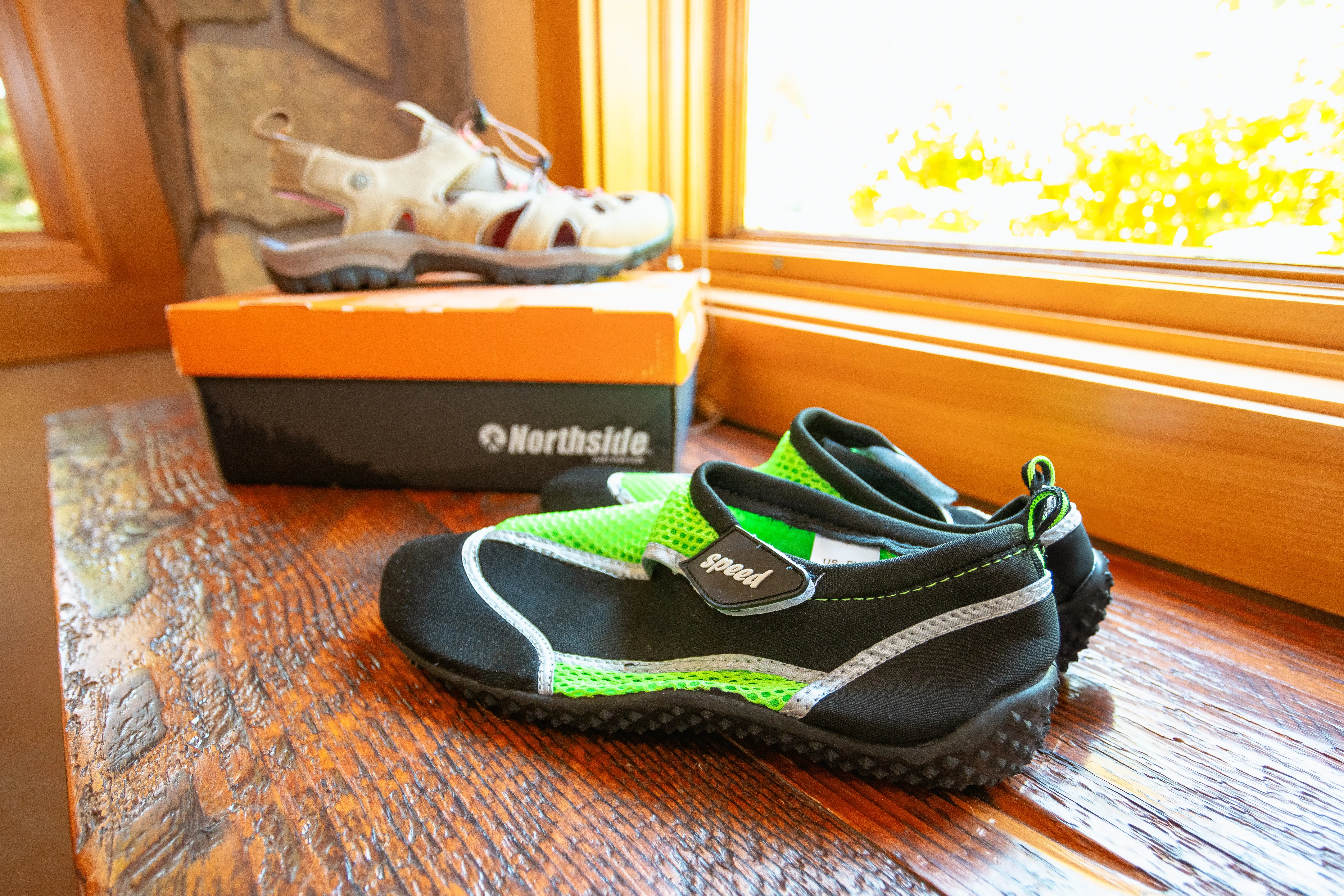 Close-up of water shoes and hiking sandals displayed on a wooden surface, perfect for outdoor activities and rafting trips at Sun Country Tours. Available for purchase at our Sunriver location.